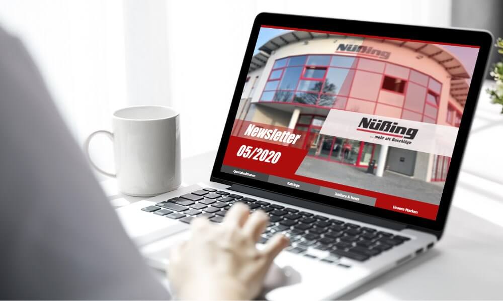 Hand am Notebook auf dem der Nüßing Newsletter dargestellt wird
