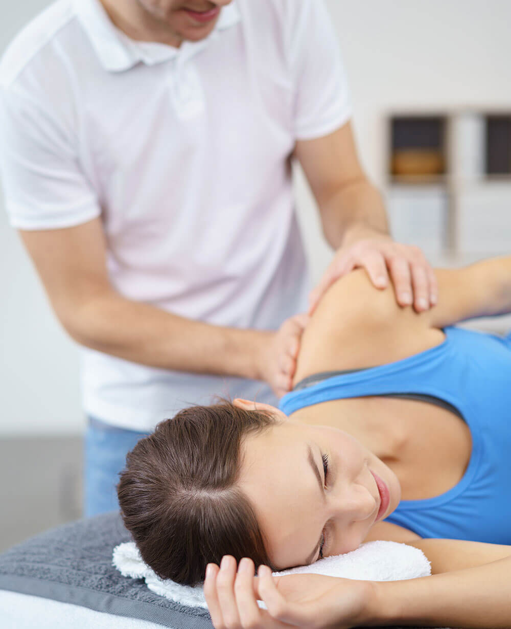 Eine Frau wird von einem Physiotherapeuten behandelt